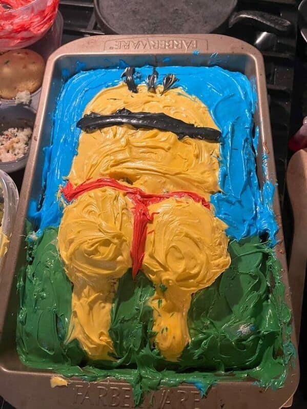 A humorous and messy sheet cake depicting a Minion character in a red thong swimsuit.
