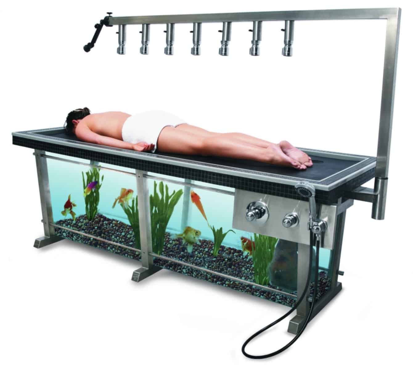 Luxury spa massage table with a built-in large aquarium base featuring colorful goldfish.
