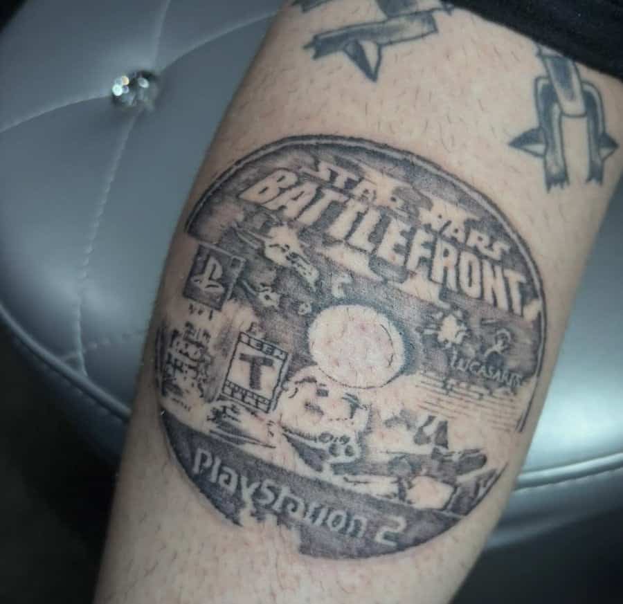 Detailed black and grey tattoo of a PlayStation 2 Star Wars Battlefront game disc.