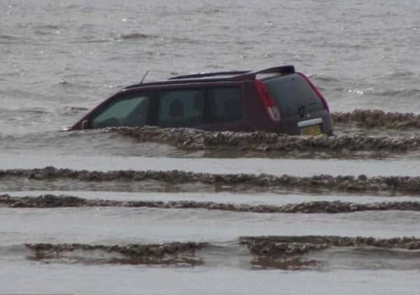 A "totaled car" bad idea meme showing a red SUV driving—or floating—deep into the ocean waves, far from the shore, during a beach trip gone horribly wrong.