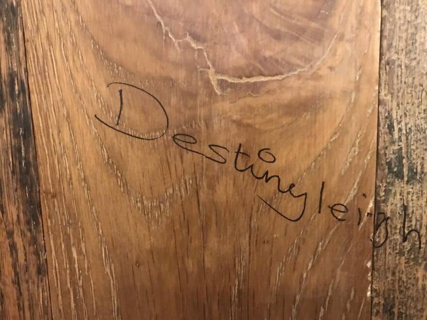 The name Destinyleigh handwritten in black ink on a textured light brown wooden surface.