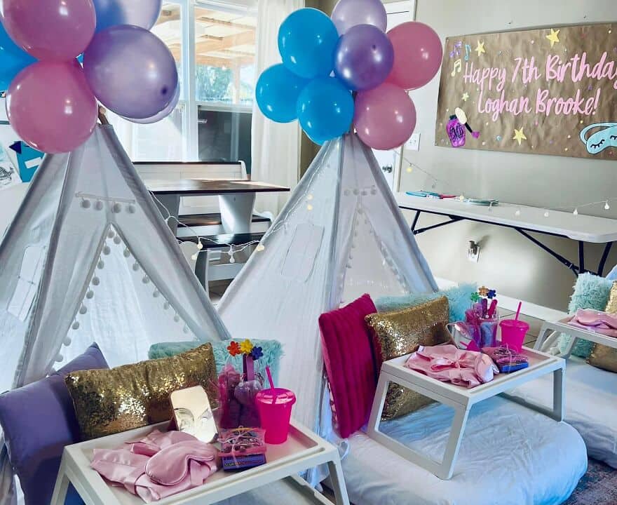 A child's birthday setup with teepees and a banner that reads Happy 7th Birthday Loghan Brooke.