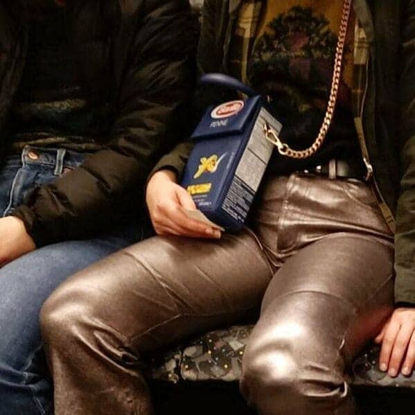 Commuter carrying a designer handbag shaped exactly like a blue box of Barilla pasta.
