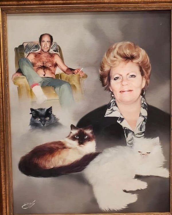 bizarre family portrait discovered as one of the best thrift store finds, featuring a large central woman surrounded by three different fluffy cats and a small, shirtless man lounging in an armchair in the background.