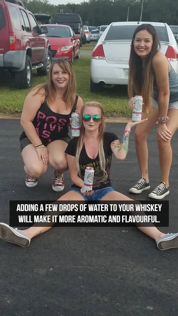 Three women posing with hard seltzer cans featuring text about adding water to whiskey flavor.