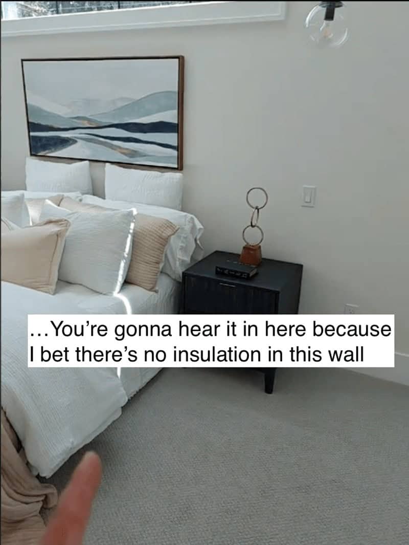 Modern bedroom with a large painting above the bed situated against a thin uninsulated wall.