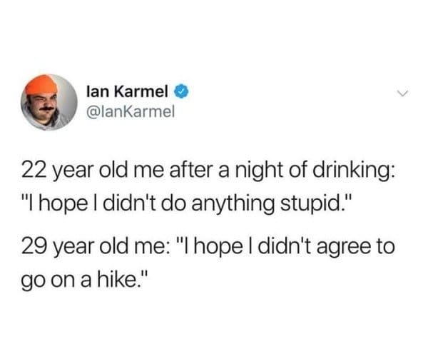 relatable classic meme tweet by Ian Karmel that contrasts the anxieties of aging: a 22-year-old fears they did something stupid while drinking, whereas a 29-year-old only fears they accidentally agreed to go on a hike.
