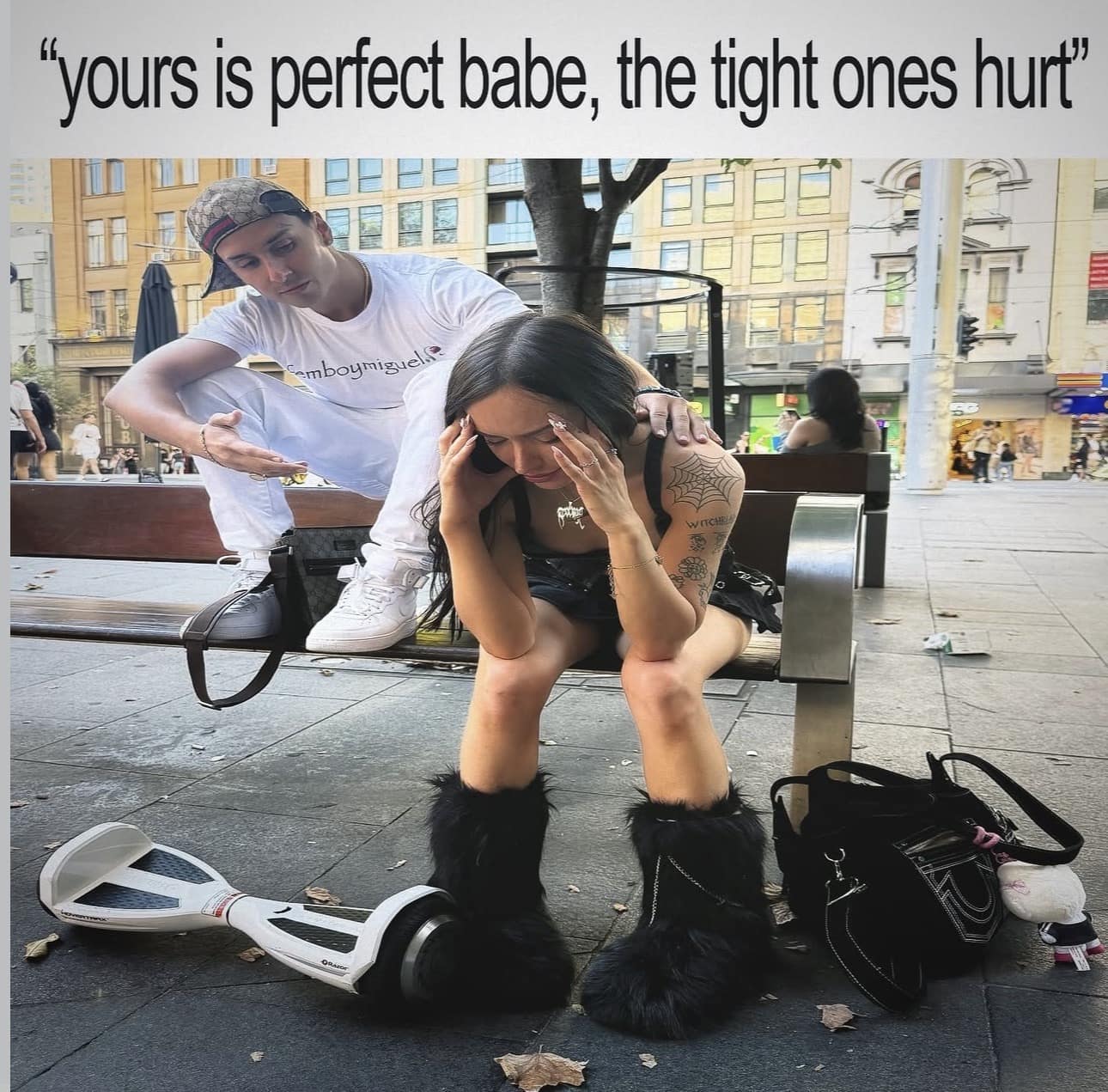 viral classic meme depicting a young woman crying on a public bench while being "consoled" by a man in a designer hat. The ironic caption, "yours is perfect babe, the tight ones hurt," parodies toxic relationship reassurances.