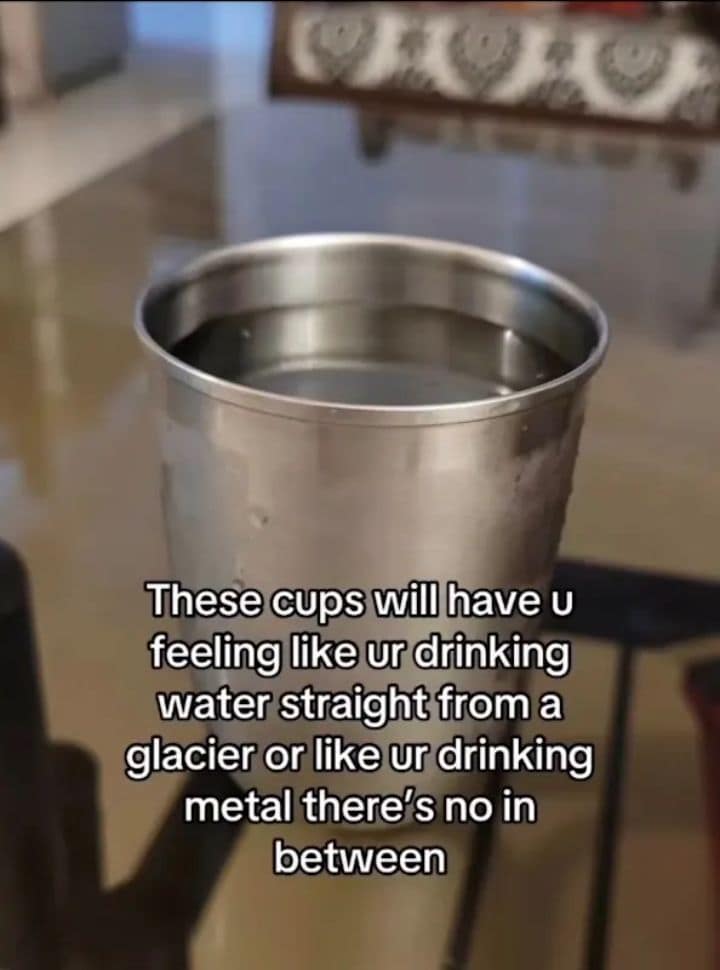 An old memes staple featuring a first-person view of a stainless steel cup filled with water. The overlay text perfectly captures the sensory experience: "These cups will have u feeling like ur drinking water straight from a glacier or like ur drinking metal there's no in between."