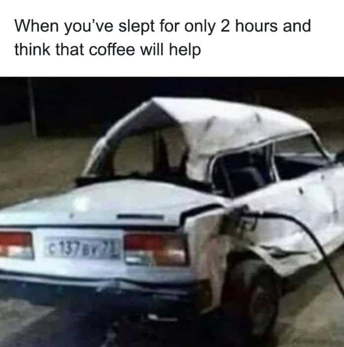 A severely wrecked white car being fueled at a gas station representing caffeine on little sleep.