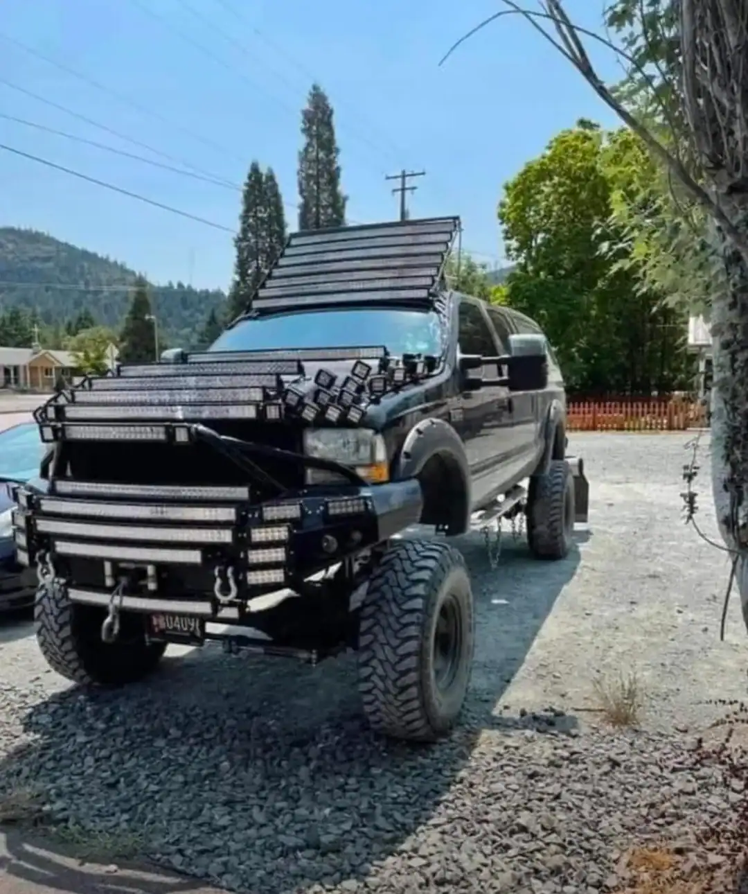 Black lifted pickup truck covered in dozens of LED light bars across the hood and roof.
