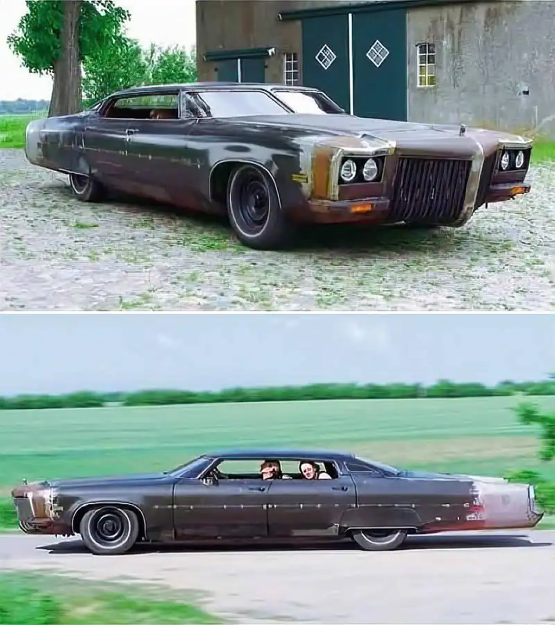 Long, rusted custom sedan with a flattened roofline and an aggressive, industrial-style front grille and body.