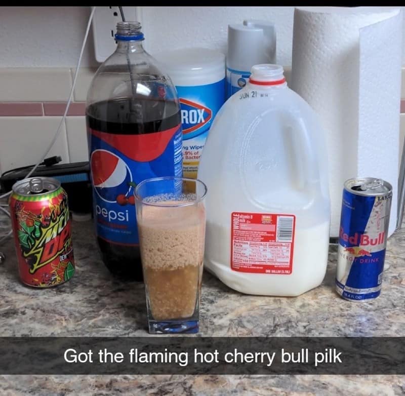 A chaotic kitchen counter display of a "Pilk" variation, where a glass is filled with a nauseating mixture of Mountain Dew, Pepsi, Red Bull, and whole milk, aptly dubbed "flaming hot cherry bull pilk."