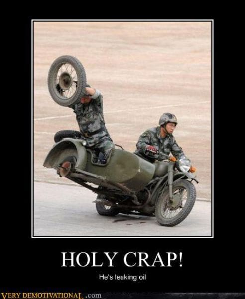 A high-action demotivational poster titled "HOLY CRAP!" The photo depicts a military sidecar stunt where a soldier is literally standing in the sidecar and holding the detached wheel above his head while the bike is in motion. The deadpan subtext: "He's leaking oil."