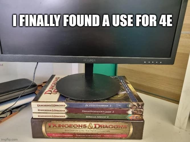 savage d&d meme displaying a computer monitor sitting atop a stack of Dungeons & Dragons 4th Edition rulebooks. The caption reads, "I FINALLY FOUND A USE FOR 4E," poking fun at the polarizing edition's secondary utility as a monitor stand.