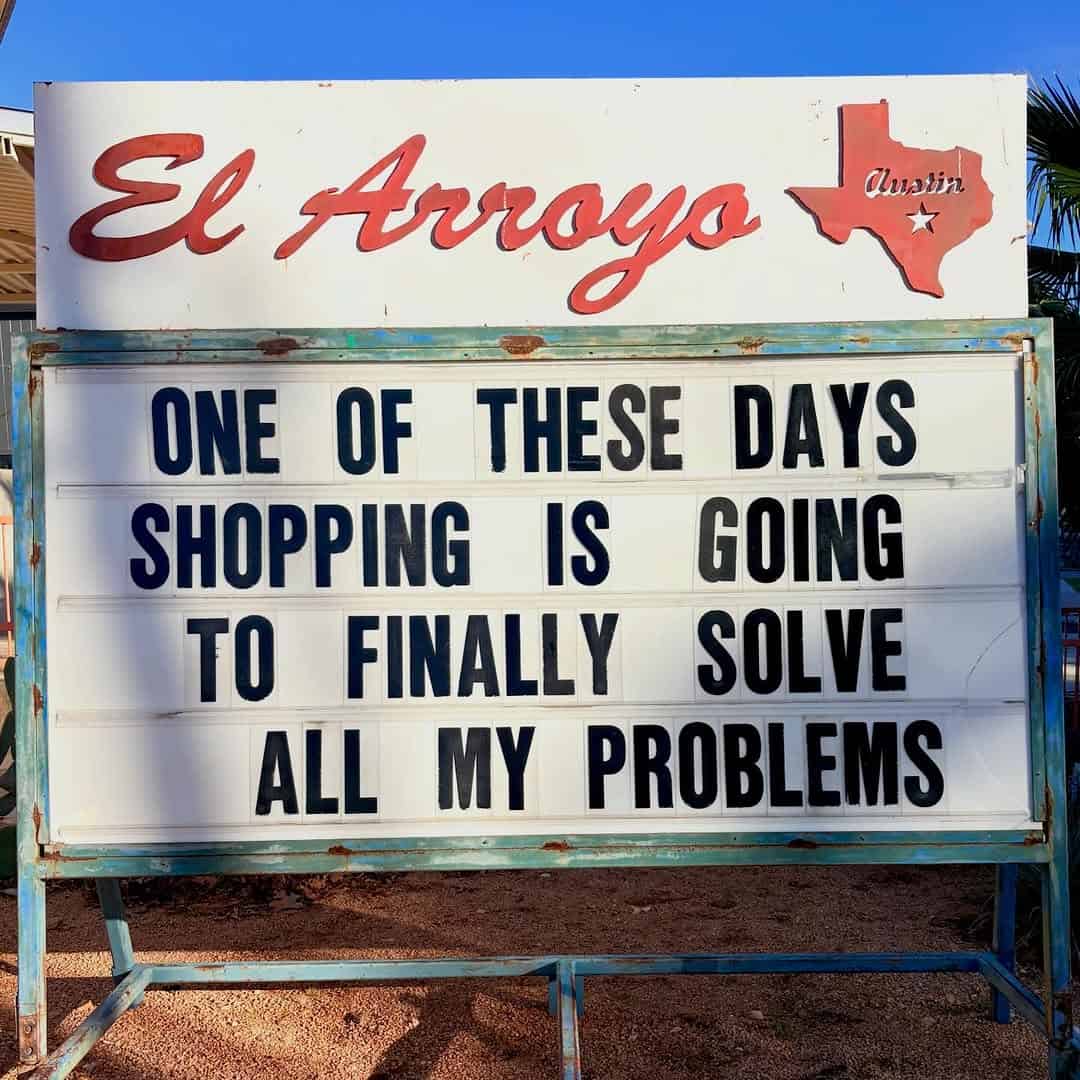 Relatable retail therapy humor displayed on an el arroyo sign reading one of these days shopping is going to finally solve all my problems in this classic funny restaurant sign
