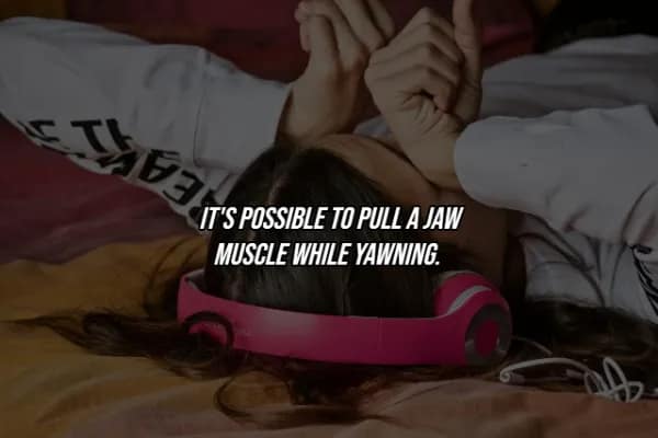 A woman lying on a bed with headphones around her neck, featuring a facts about the human body caption about the surprising risk of pulling a jaw muscle during a simple yawn.