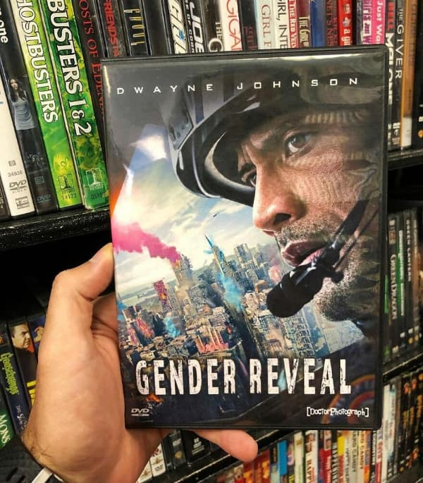 A fake DVD cover for an action thriller funny fake movie poster titled "Gender Reveal." It shows a battle-worn Dwayne Johnson in a tactical helmet looking out over a city where a catastrophic explosion is releasing a massive, towering plume of bright pink smoke.