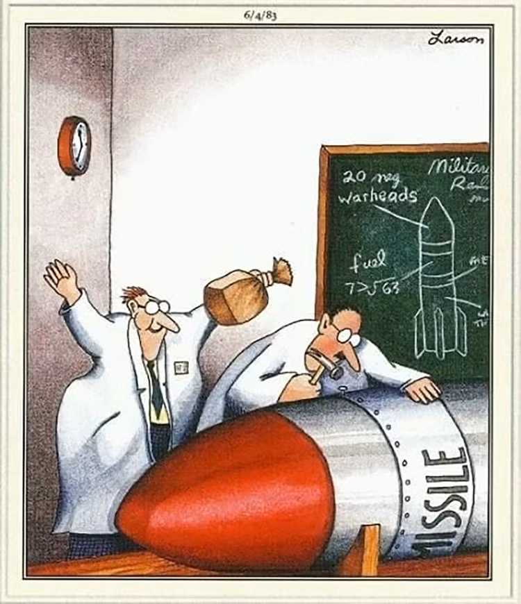 high-stakes laboratory far side comic where two scientists are working on a massive, red-tipped "MISSILE." As one scientist carefully uses a hammer on the hull, his colleague sneaks up behind him, holding an inflated paper bag, ready to pop it for a catastrophic prank.