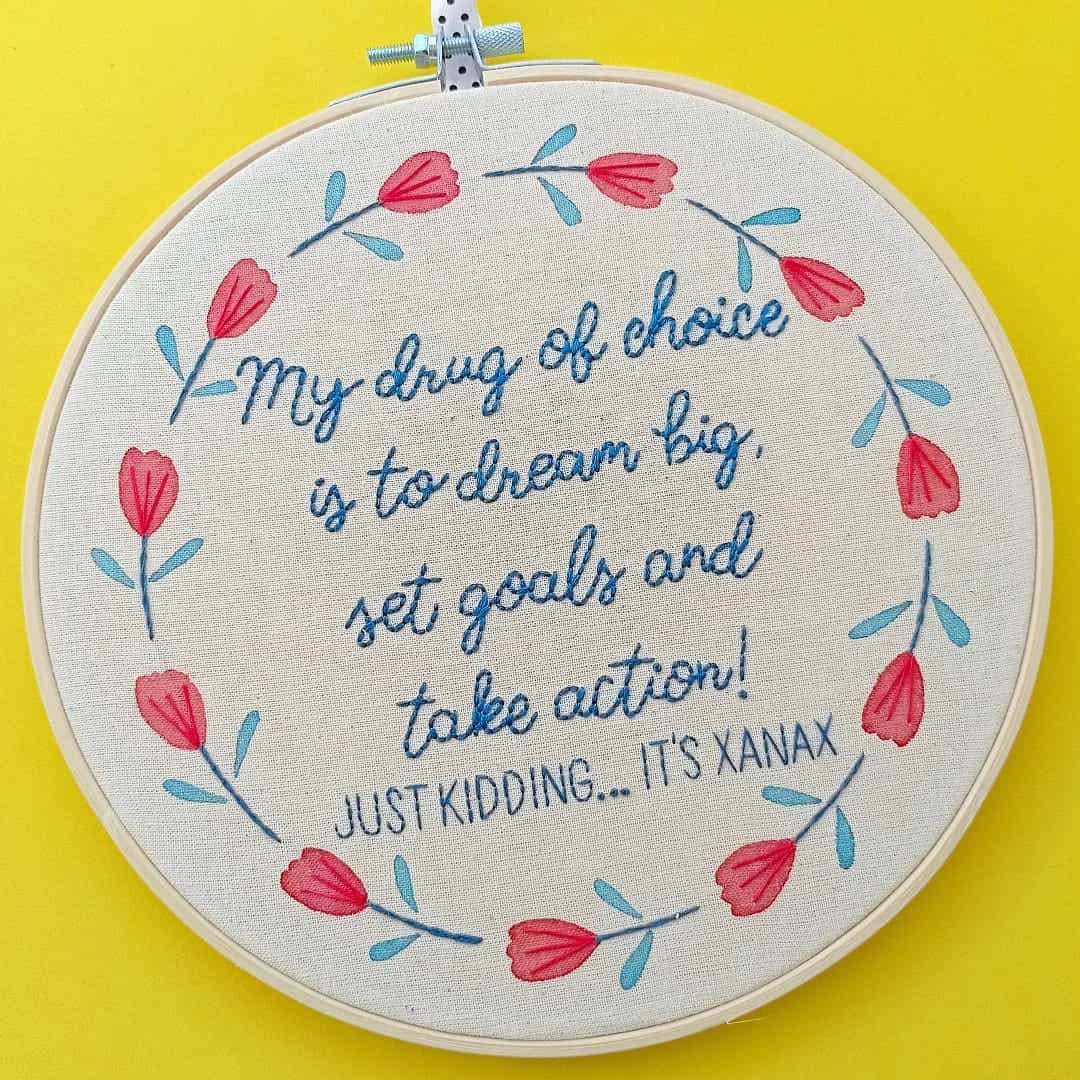 Floral embroidery with a fake inspirational quote that ends by mentioning the drug Xanax.