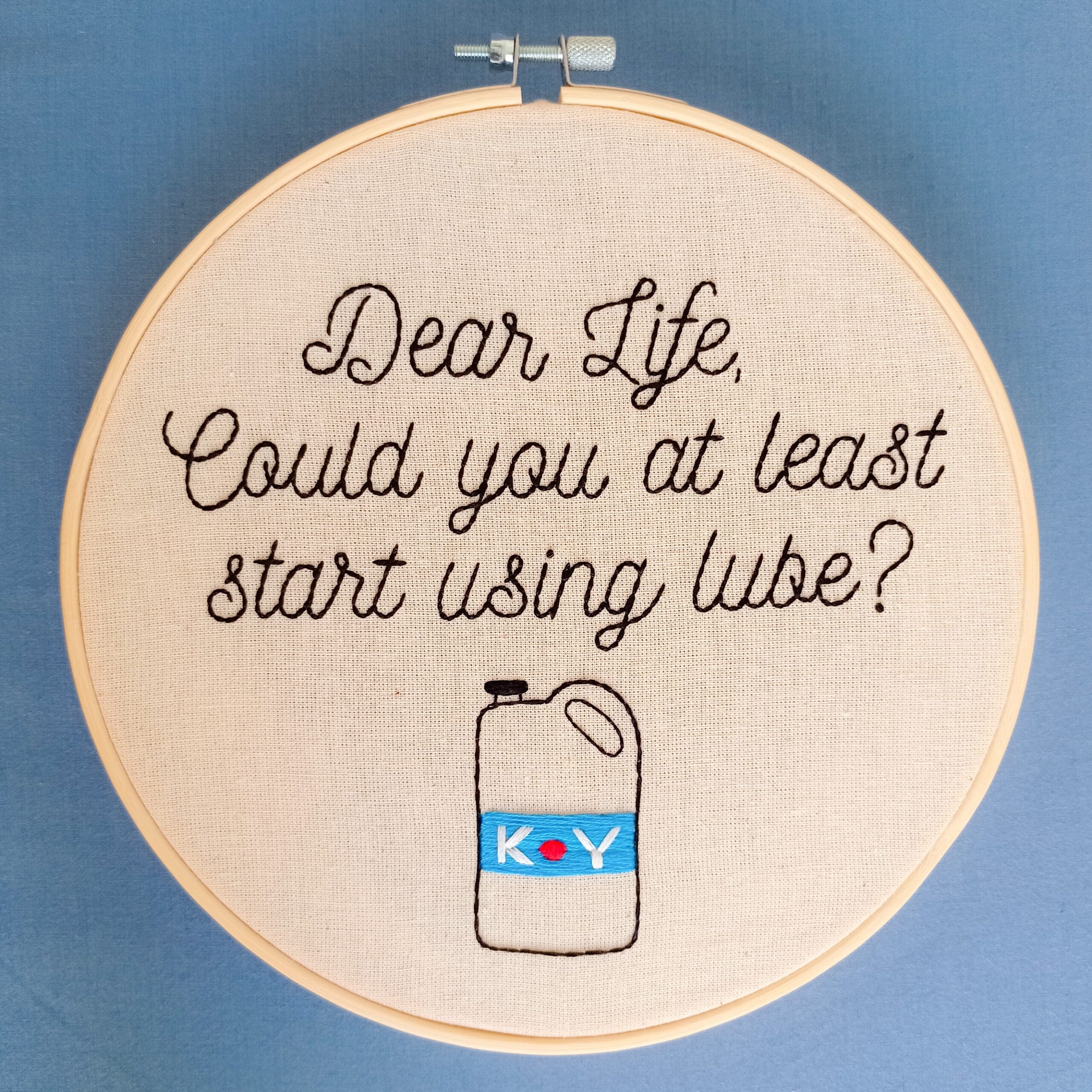 Embroidery with a cursive message addressed to life featuring an illustration of K-Y Jelly.