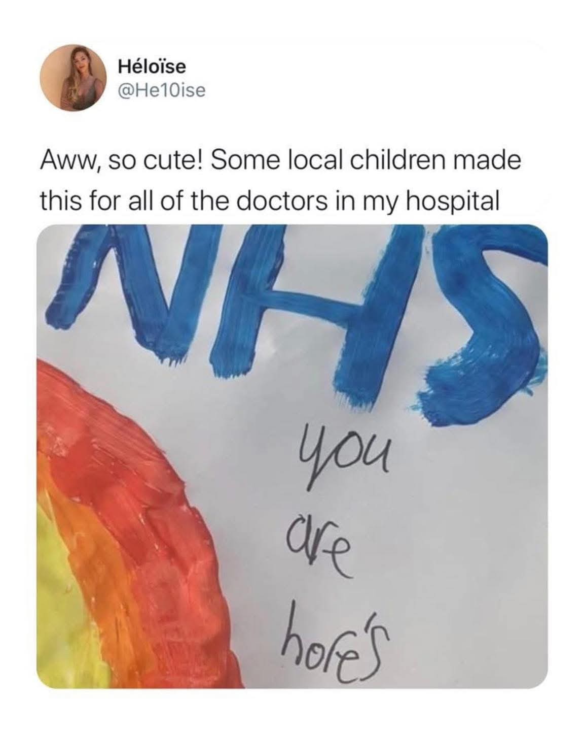A child's hand-painted NHS rainbow sign that accidentally looks like it says you are hores.
