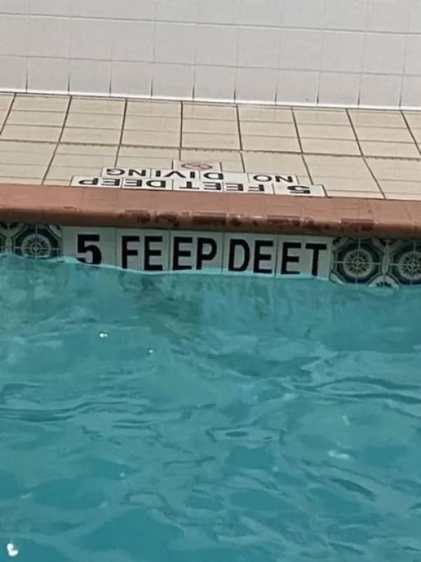 Misaligned pool tiles spelling out 5 FE EP DEET instead of 5 feet deep.