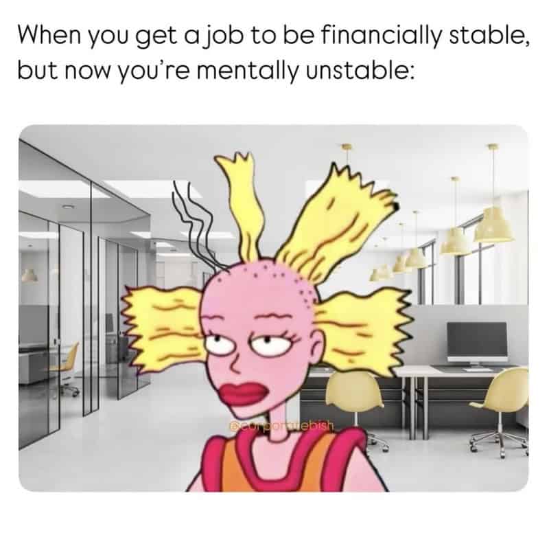 The completely fried, bald, and disheveled Cynthia doll from Rugrats photoshopped into a clean modern office, brilliantly illustrating a work meme about completely sacrificing your mental stability just to achieve financial stability