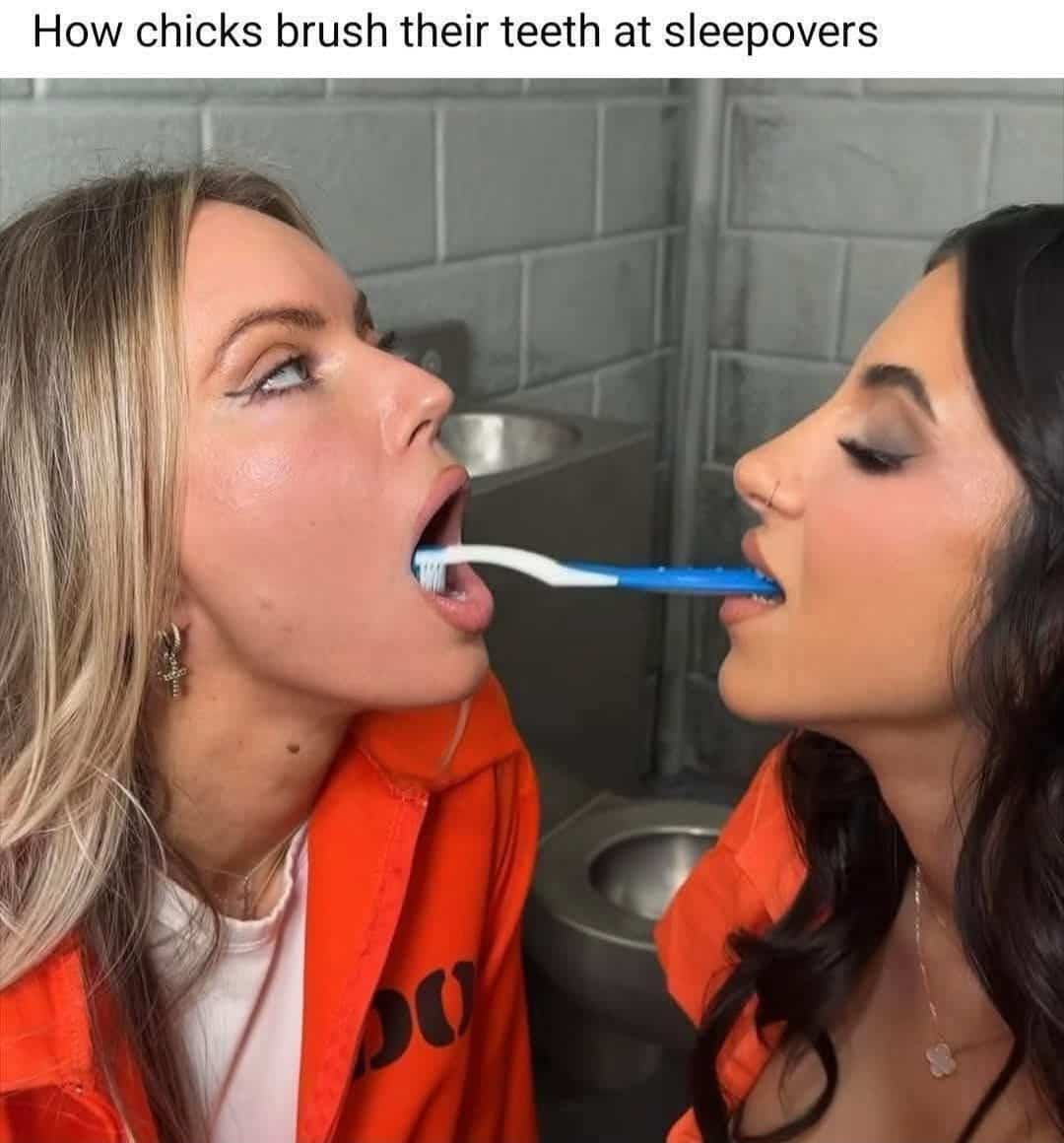 Two women in orange prison jumpsuits share a toothbrush in a comical jail cell scene.