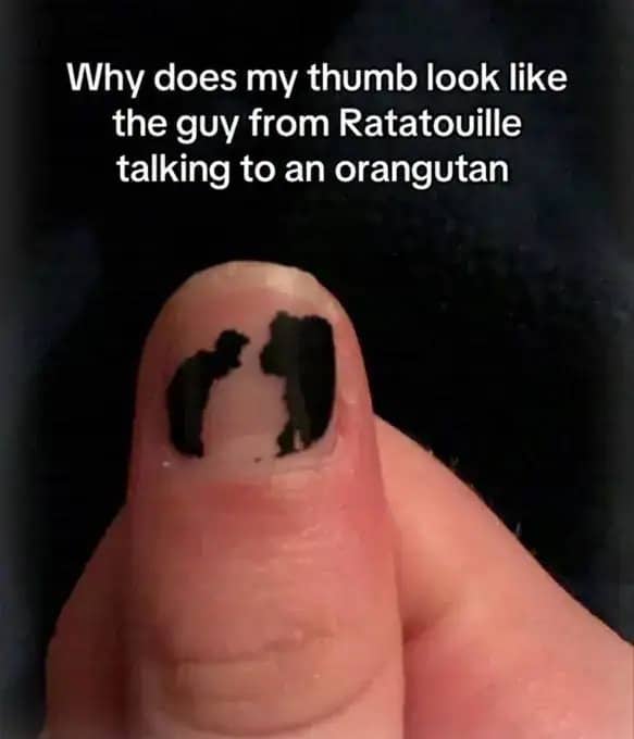 A thumb with chipped black nail polish that resembles silhouettes of characters from Ratatouille.