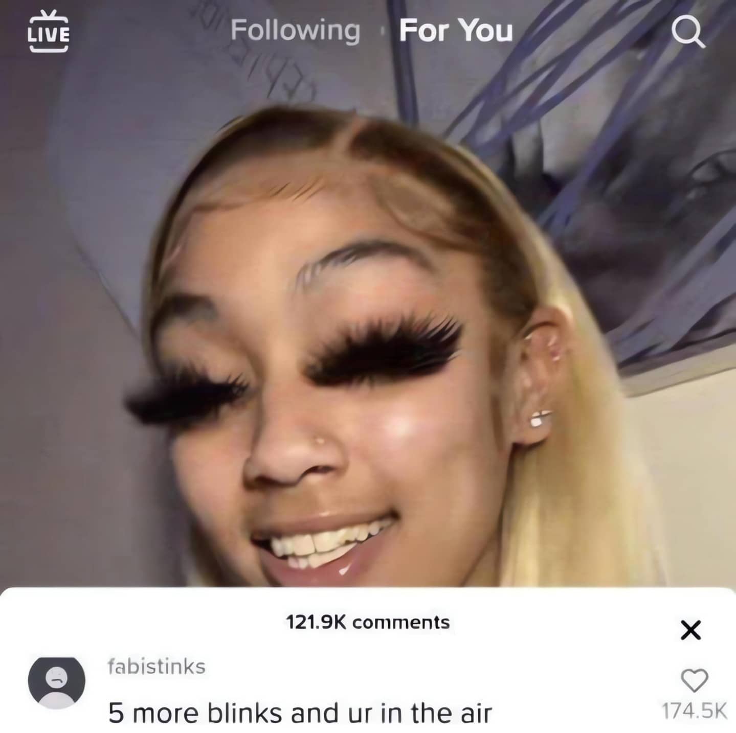 Woman with extremely long and thick black false eyelashes with a funny social media comment.