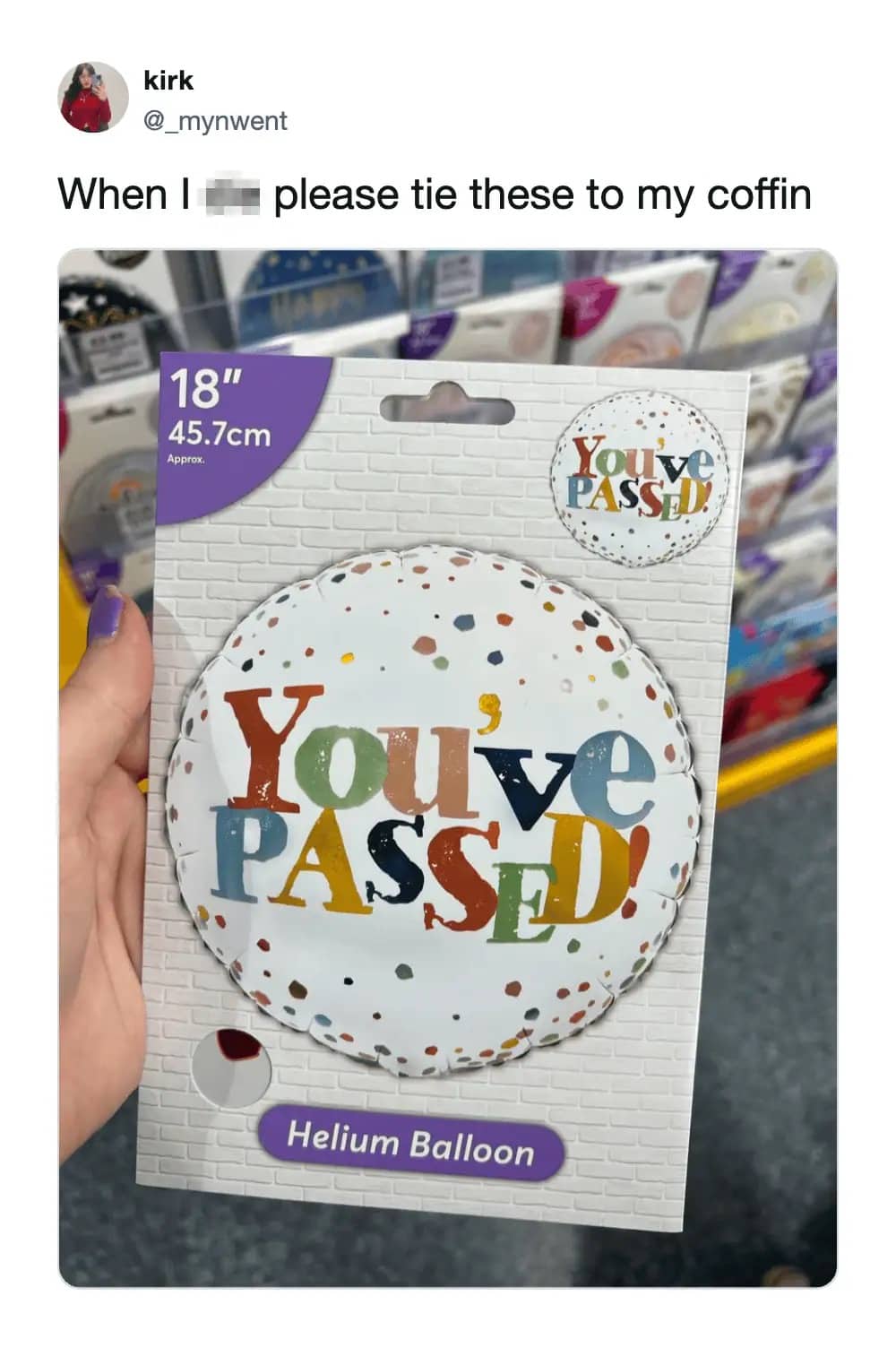 Hand holding a "You've Passed!" helium balloon package with a joke about funeral decorations.