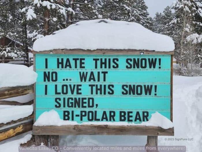 In a snow-covered landscape, a teal marquee sign perfectly captures winter mood swings with the message: "I HATE THIS SNOW! NO ... WAIT I LOVE THIS SNOW! SIGNED, BI-POLAR BEAR."