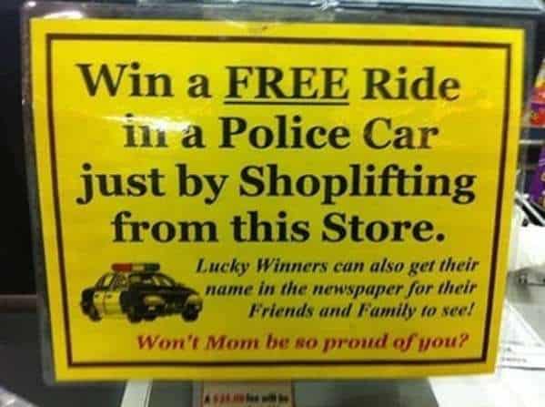 A brightly colored yellow funny sign posted in a shop window. It sarcastically offers a "FREE Ride in a Police Car just by Shoplifting," adding that "Lucky Winners" can see their names in the local newspaper, making their moms "so proud."