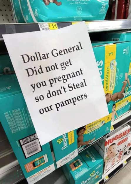 savage funny sign posted in the diaper aisle of a Dollar General store. The printed message takes an aggressive, no-nonsense stance against theft: "Dollar General Did not get you pregnant so don't Steal our pampers."