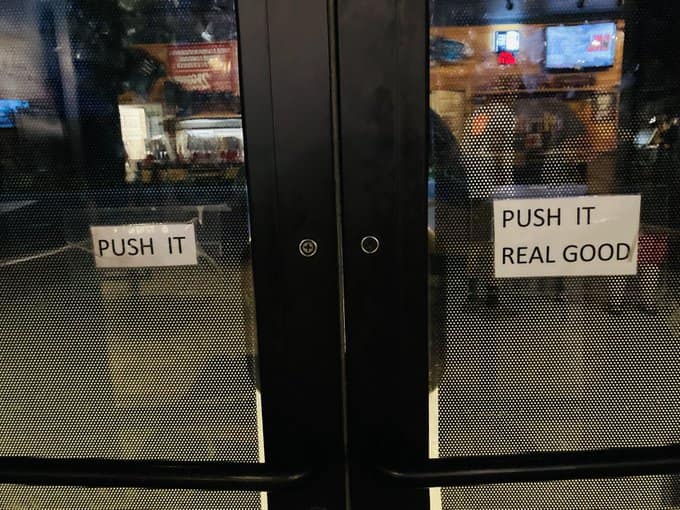 A set of double glass doors features a clever musical pun with two stickers: the left one says "PUSH IT" and the right one finishes the Salt-N-Pepa lyric with "PUSH IT REAL GOOD."