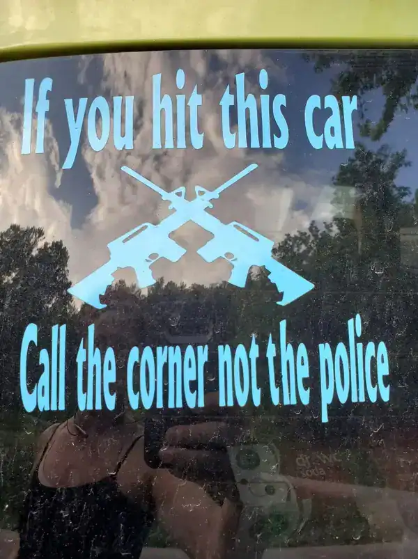 car window decal featuring crossed rifles and a threatening message that backfires due to a funny spelling fail, telling people to "Call the corner" instead of the "coroner" if they hit the car.