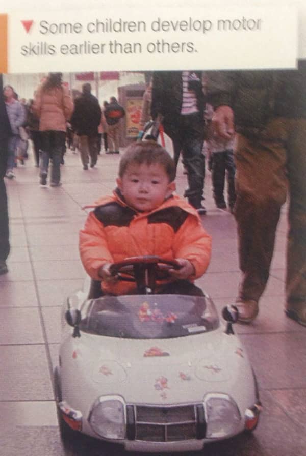 Educational photo of a toddler driving a small motorized car to illustrate early motor skills.