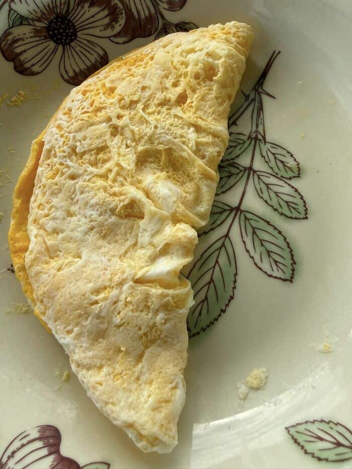 culinary example of inanimate objects with faces showing a folded breakfast omelet on a plate, where the cooked egg perfectly mimics the distinct side profile of a human face.