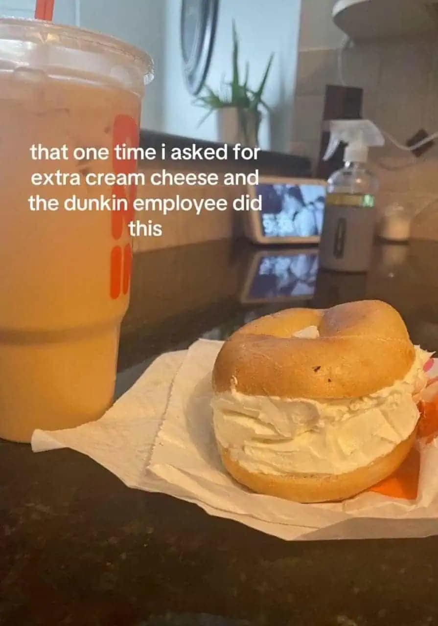 A hilarious meme from a meme dump showing a Dunkin’ bagel with a ludicrously thick, two-inch slab of cream cheese overflowing from the center after the customer made the mistake of asking for "extra."