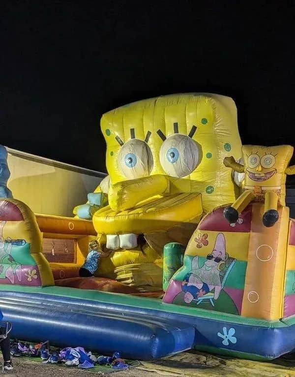 A "cursed" entry in this meme dump featuring a terrifying bootleg inflatable SpongeBob SquarePants bouncy house. The character has a long, phallic nose, wide bulging eyes, and a disturbing smile, looking more like a monster from a horror film than a cartoon character.