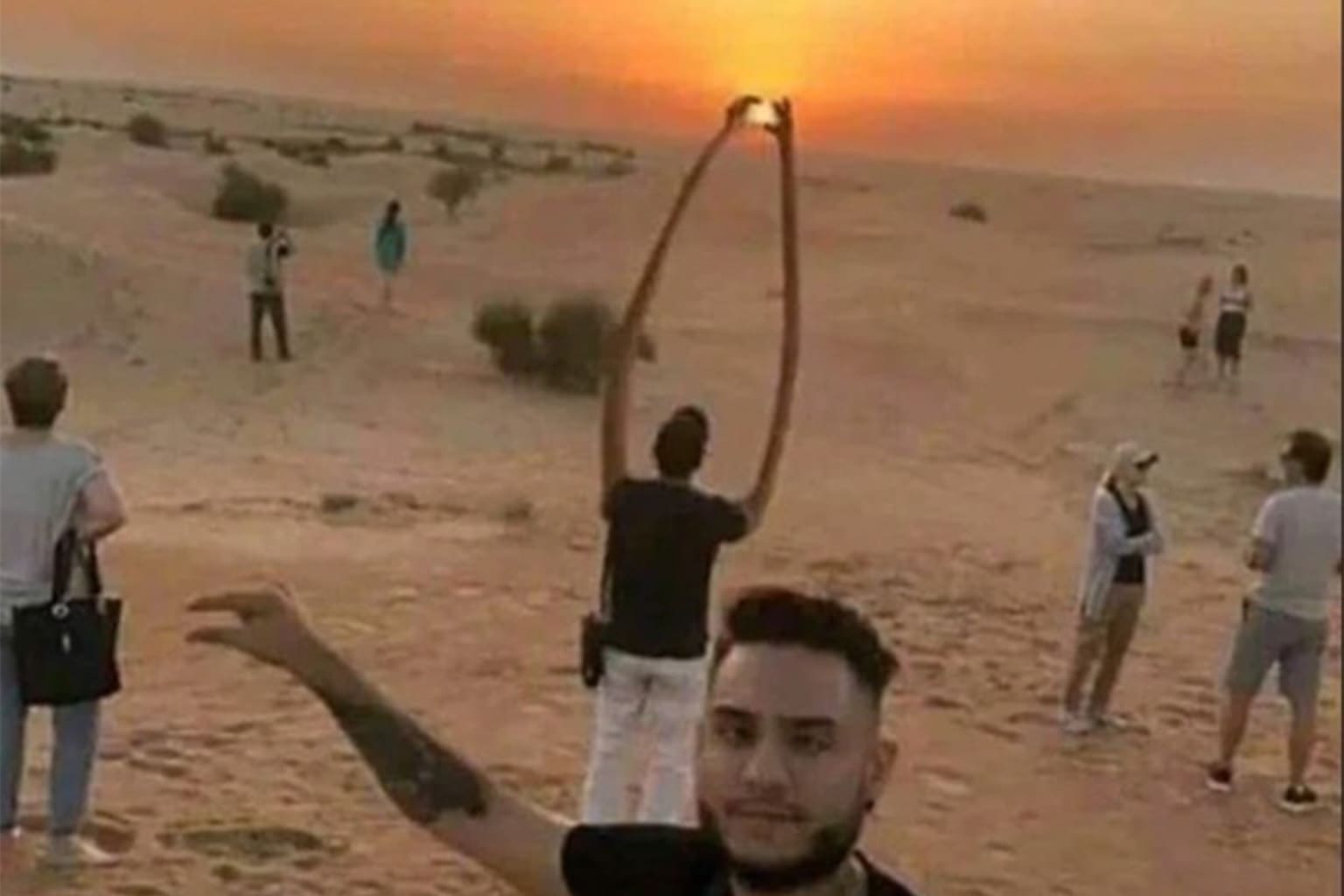 A meme dump of funny memes featuring a warped, cartoonish bookshelf and dresser combo, a surreal desert photo of a man "pinching" the setting sun with elongated arms, and a cursed close-up of a foot resting in a sand-filled ashtray full of cigarette butts.