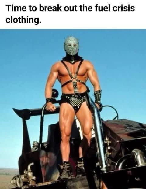 topical funny meme featuring the muscular, masked villain Lord Humungus from Mad Max standing on a vehicle, captioned: "Time to break out the fuel crisis clothing."