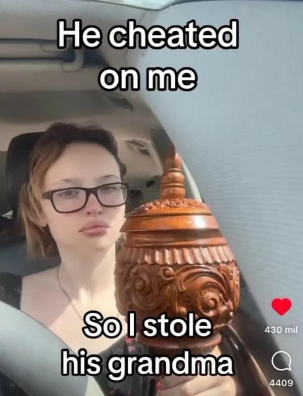 savage revenge hilarious meme showing a stone-faced woman sitting in the driver's seat of her car, holding a massive wooden cremation urn after proudly stealing her cheating boyfriend's literal grandma.