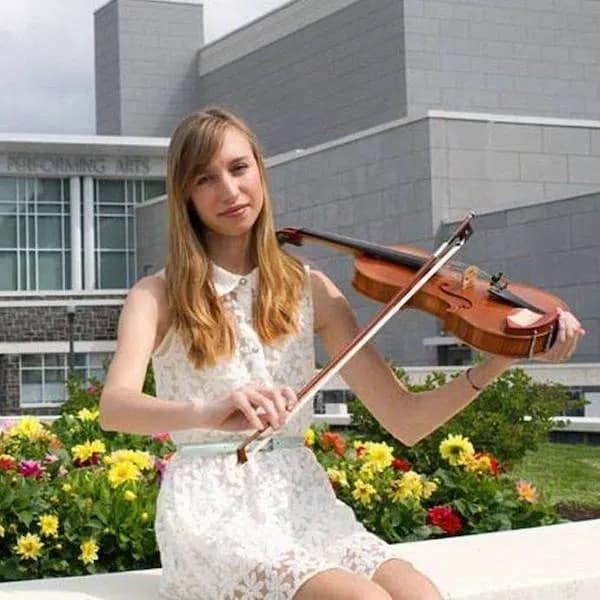 classic "stock photo" fail found in this meme dump showing a girl posing with a violin in a garden. The humor comes from her holding the bow underneath the strings and bridge, making it physically impossible to play the instrument.