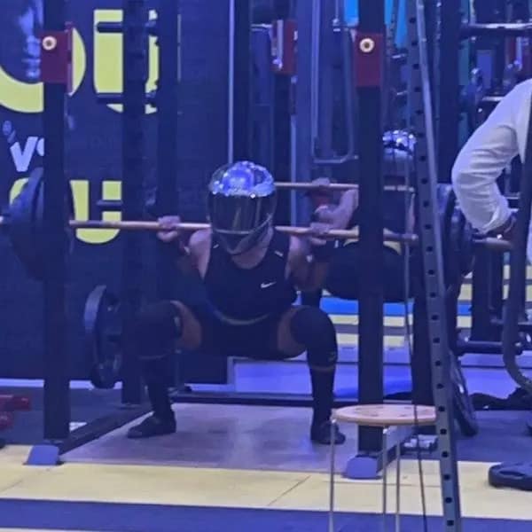 Unhinged gym culture in this meme dump showing a person aggressively doing heavy barbell squats while safely wearing a fully closed shiny silver motorcycle helmet. A truly hilarious meme.