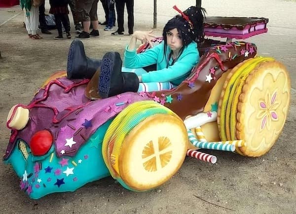 A funny meme showing an incredibly unamused cosplayer perfectly dressed as Vanellope von Schweetz sitting inside a highly detailed candy kart, serving as a great visual for this meme dump.
