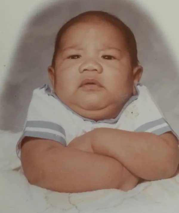 Cross-armed baby with a stern expression looking like a bouncer at an exclusive milk bar.