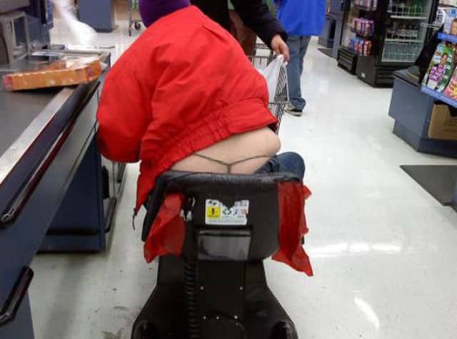 Person on a mobility scooter at checkout wearing a red jacket with visible thin thong.