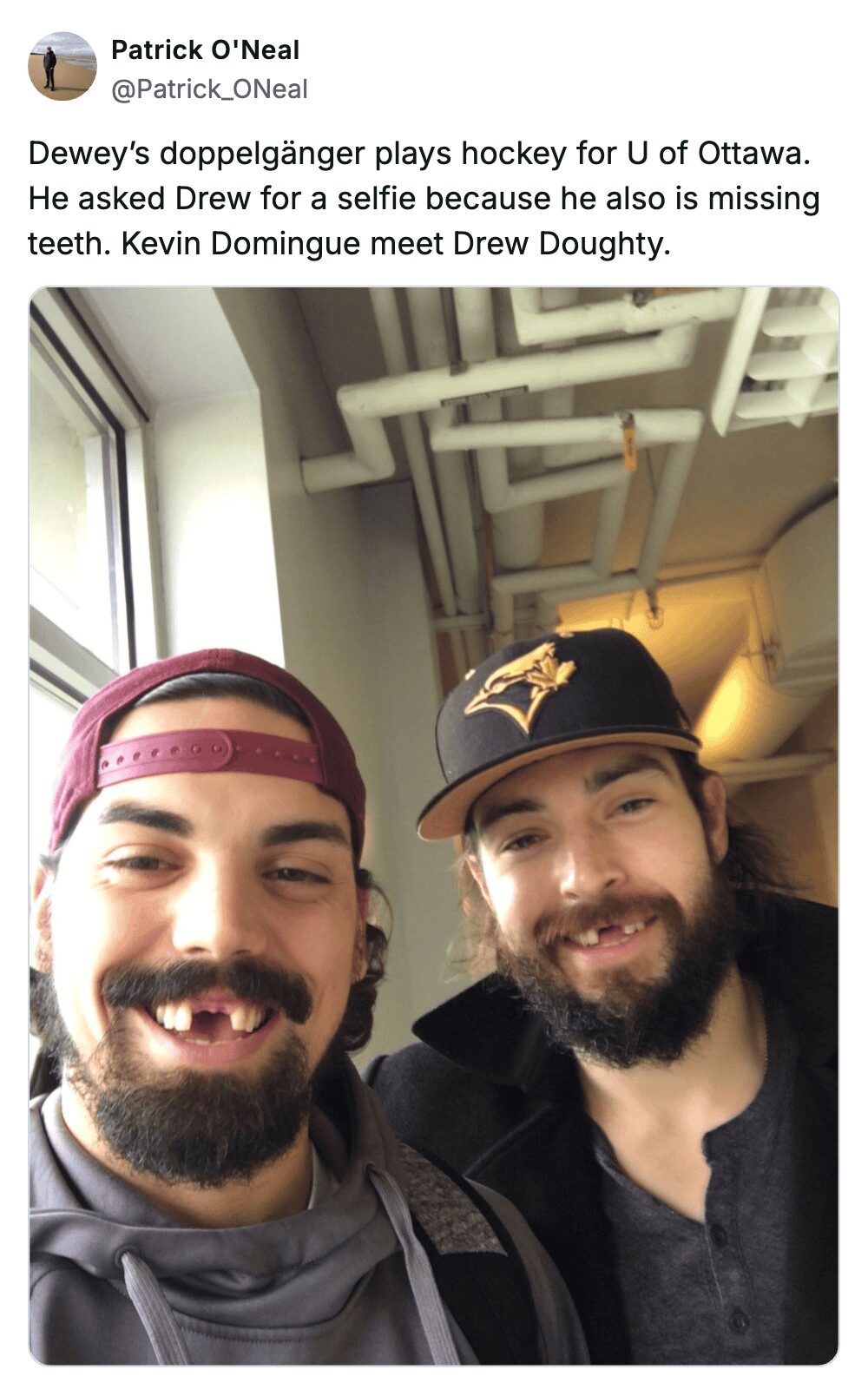 Hockey players Kevin Domingue and Drew Doughty smiling while showing off their matching missing front teeth.